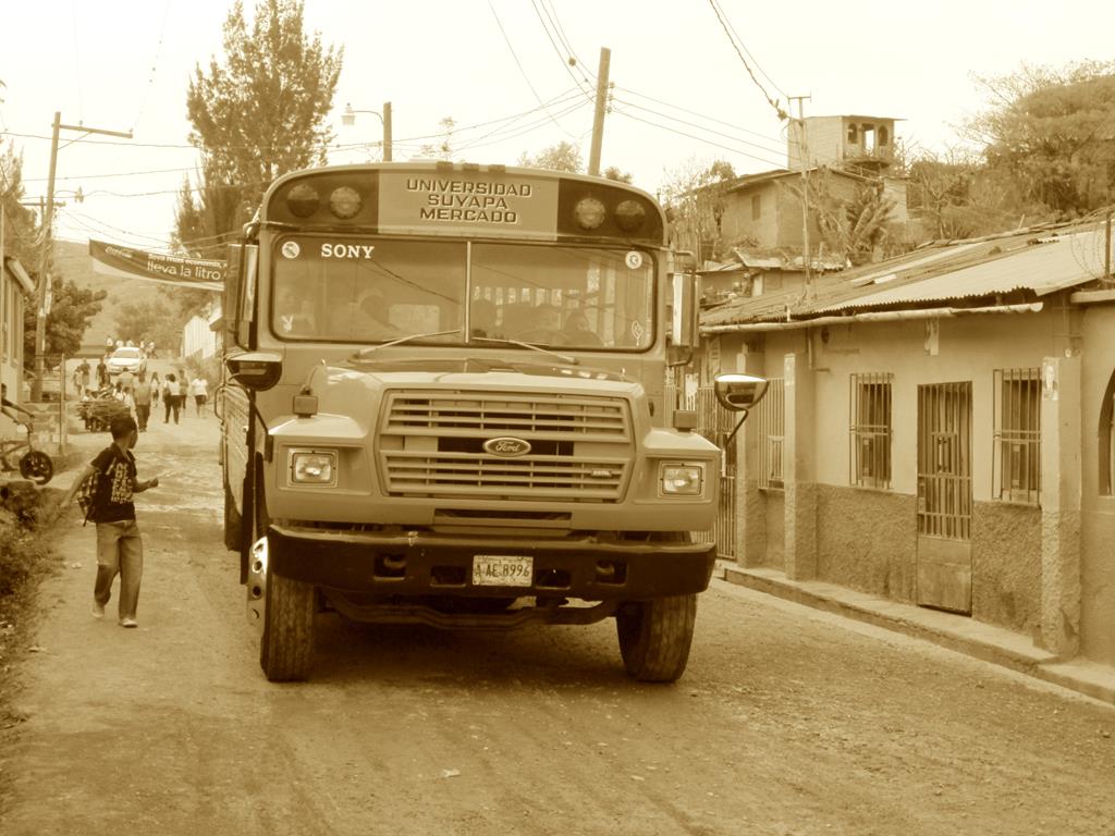 En tonstung skolebus kommer kørende i slumkvarteret. Bag rattet sidder en blot 12-årig dreng og smiler bredt!